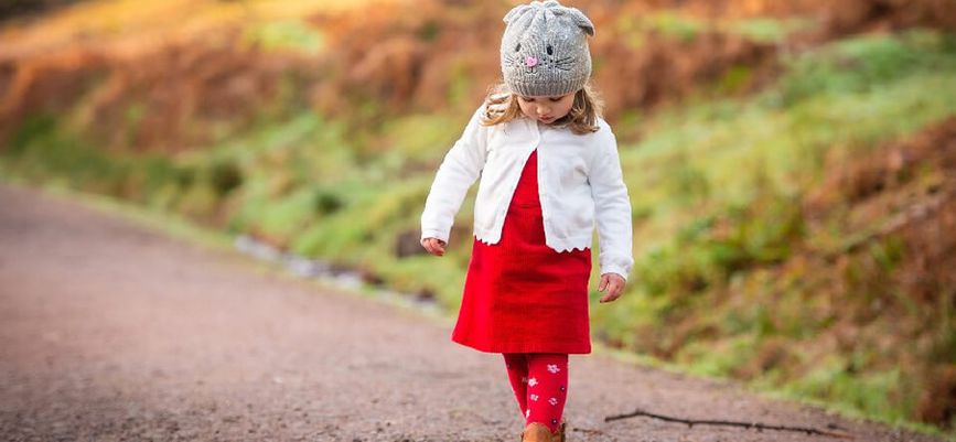 Pieni tyttö kävelee tiellä