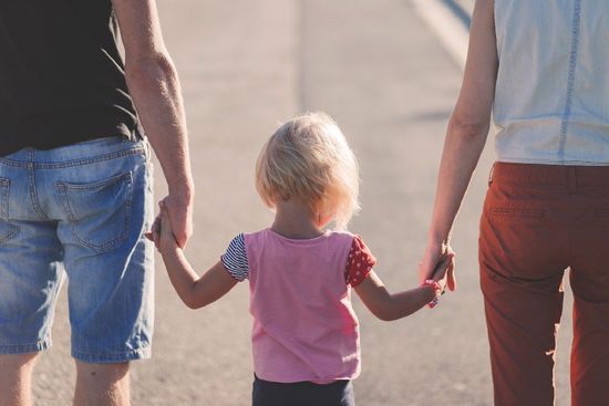 Lapsi pitelee vanhempiaan käsistä. Siirry Sähköisen perhekeskuksen Tukea vanhemmille -sivulle.